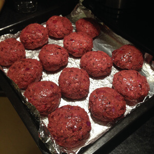 A batch of beetroot bean and sunflower seed burgers on a baking tray.